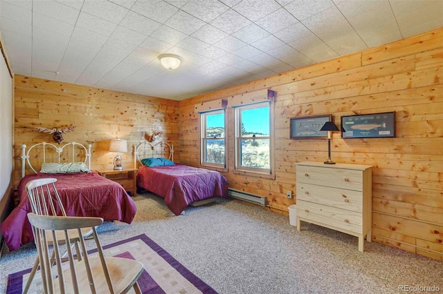 carpeted bedroom with a baseboard heating unit and wood walls