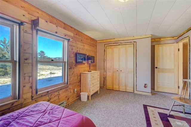 bedroom with carpet flooring, multiple windows, and wooden walls