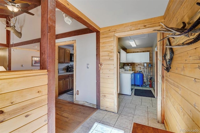 hallway with washer / dryer and light tile patterned floors