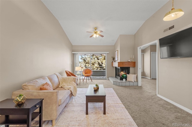 carpeted living room featuring a fireplace, ceiling fan, and lofted ceiling