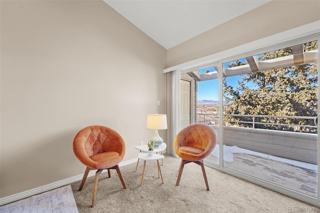 sitting room featuring carpet flooring and vaulted ceiling