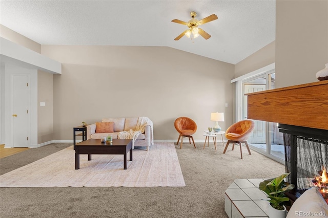 living room with ceiling fan, light colored carpet, and vaulted ceiling