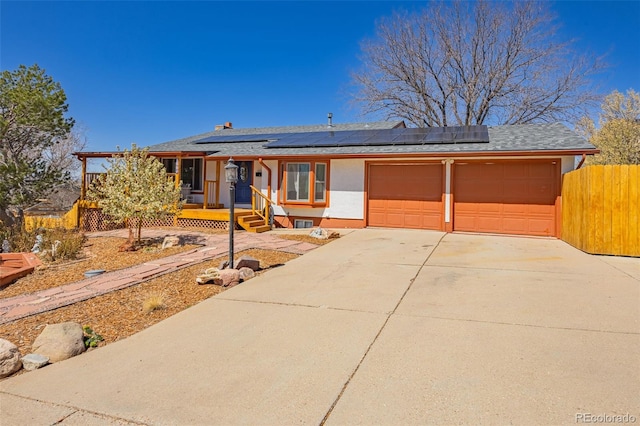 2115 Rangeview Dr, Pueblo, CO 81008 - ranch-style house featuring an attached garage, solar panels, and a shingled roof