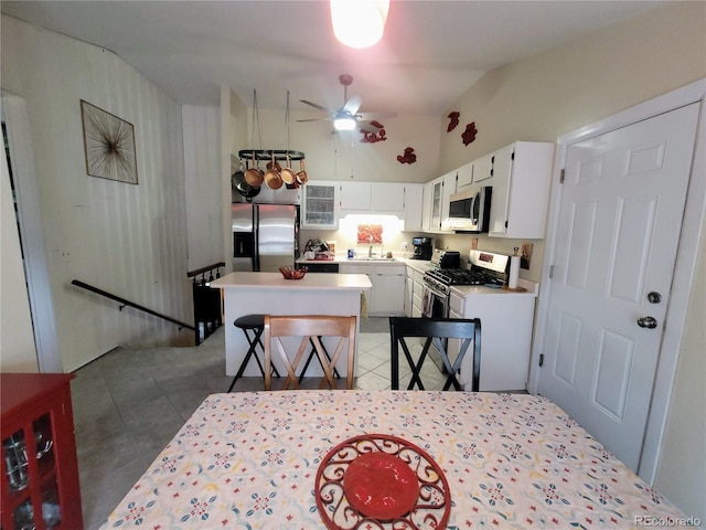 2115 Rangeview Dr, Pueblo, CO 81008 - kitchen featuring stainless steel appliances, white cabinets, ceiling fan, a kitchen island, and light countertops