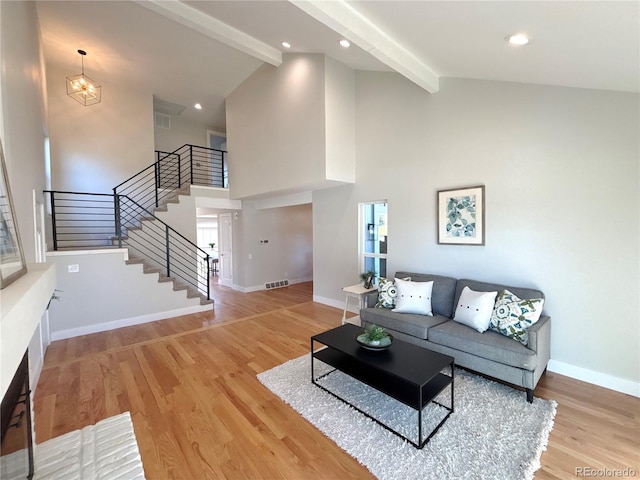 living room with hardwood / wood-style flooring, high vaulted ceiling, a chandelier, and beam ceiling