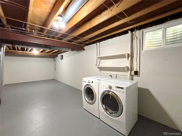 clothes washing area with washing machine and dryer