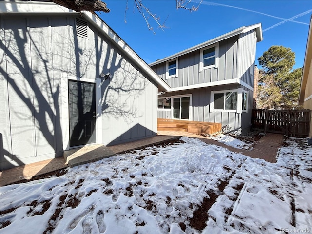 view of snow covered rear of property