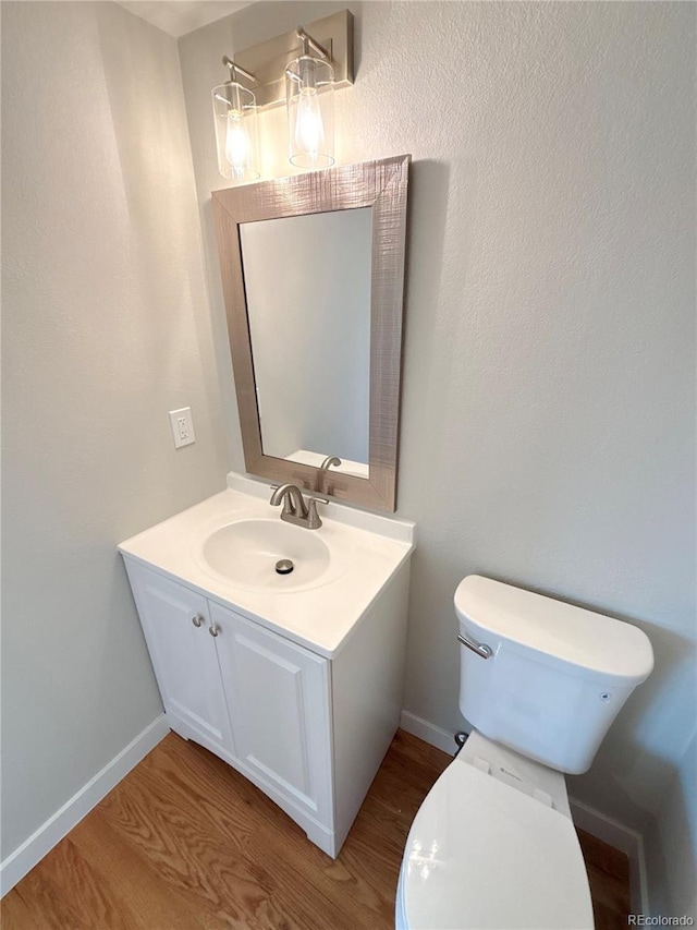 bathroom featuring vanity, hardwood / wood-style floors, and toilet