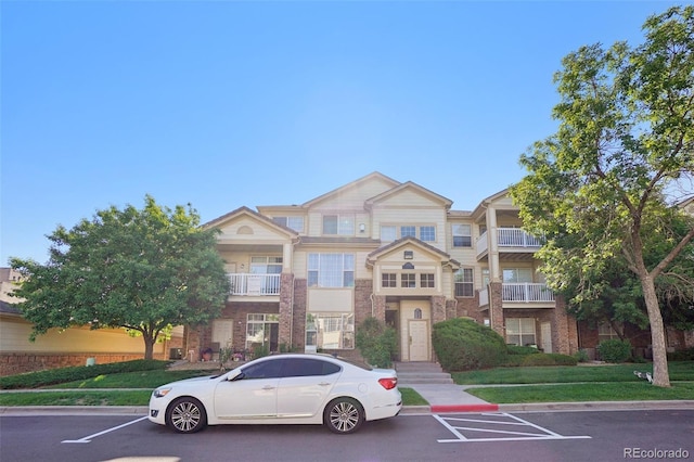 5726 N Genoa Way Unit 301, Aurora, CO 80019 - view of front of house featuring brick siding and uncovered parking