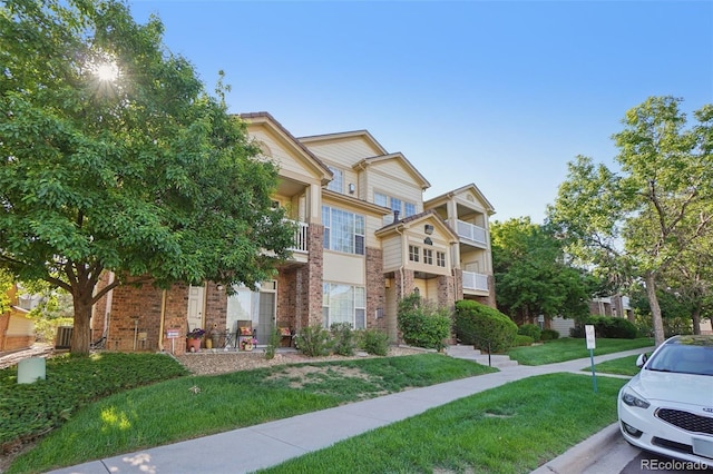 5726 N Genoa Way Unit 301, Aurora, CO 80019 - view of property featuring brick siding and a front lawn