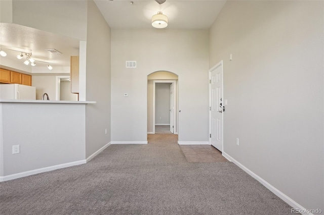 5726 N Genoa Way Unit 301, Aurora, CO 80019 - unfurnished living room with arched walkways and carpet flooring