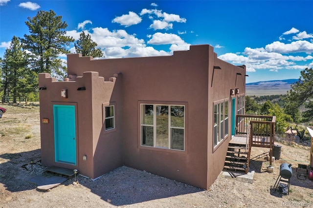 view of side of property featuring a deck with mountain view