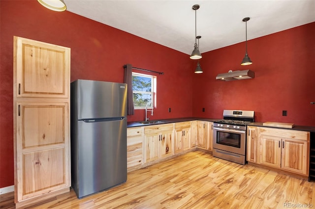 kitchen with light hardwood / wood-style flooring, stainless steel appliances, sink, and hanging light fixtures