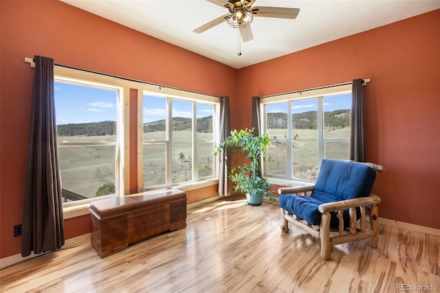 living area with ceiling fan and light hardwood / wood-style floors