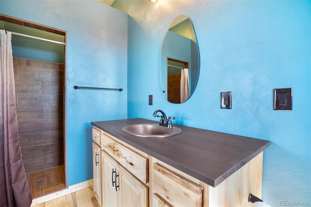 bathroom with hardwood / wood-style flooring, curtained shower, and large vanity