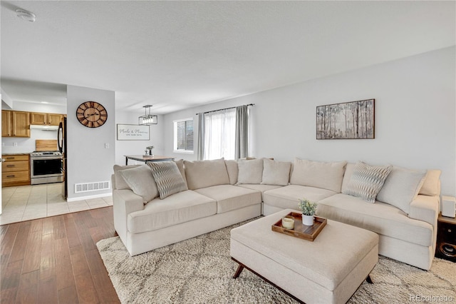 living room with visible vents and light wood-style flooring