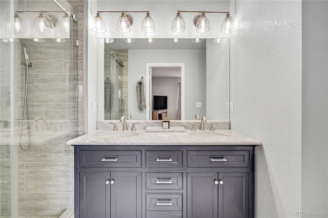 full bathroom featuring a sink, a shower stall, and double vanity