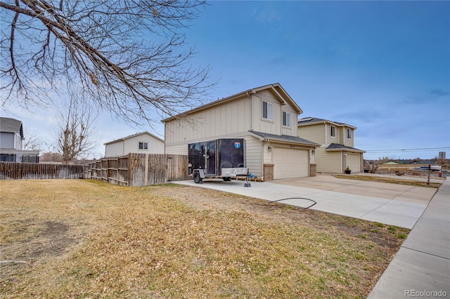 view of property exterior featuring a lawn, an attached garage, board and batten siding, fence, and driveway