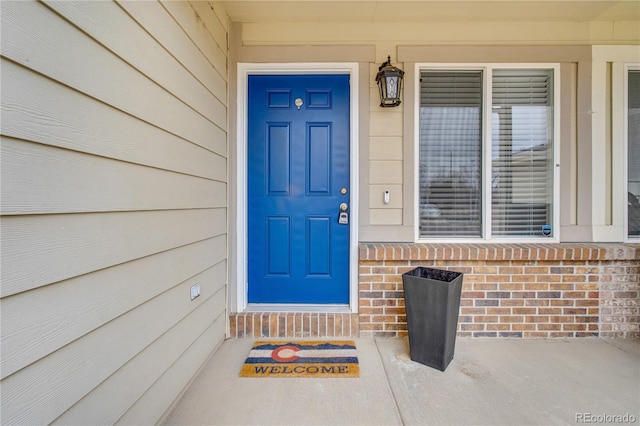 view of exterior entry with brick siding