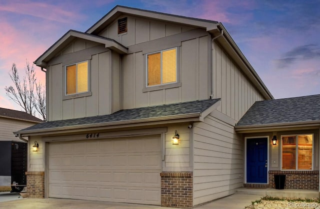 view of front of house featuring a garage, driveway, roof with shingles, board and batten siding, and brick siding