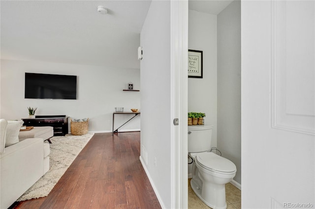 bathroom with toilet, baseboards, and hardwood / wood-style floors