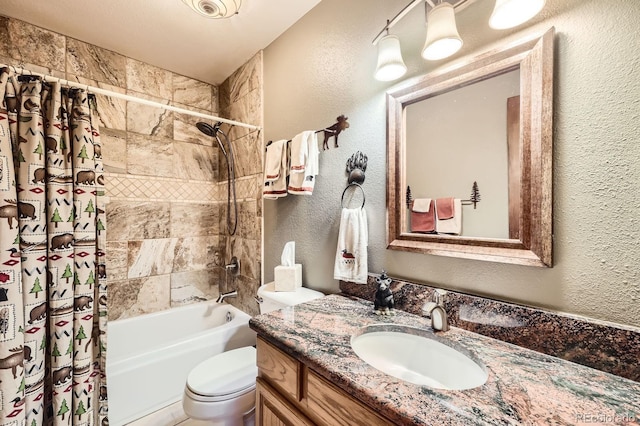 bathroom featuring shower / bath combo, visible vents, toilet, a textured wall, and vanity