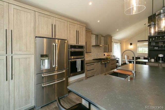 9768 Otis Dr, Westminster, CO 80021 - kitchen with dark countertops, wall chimney exhaust hood, a sink, appliances with stainless steel finishes, and vaulted ceiling