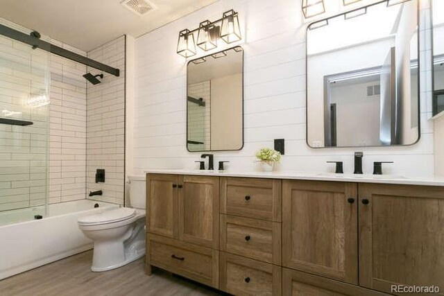 9768 Otis Dr, Westminster, CO 80021 - full bath with a sink, double vanity, toilet, wood finished floors, and visible vents
