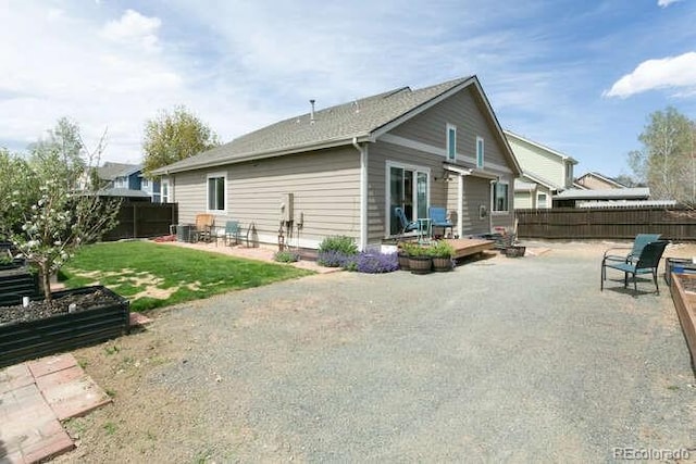9768 Otis Dr, Westminster, CO 80021 - back of house with a fenced backyard, a wooden deck, a yard, and a patio