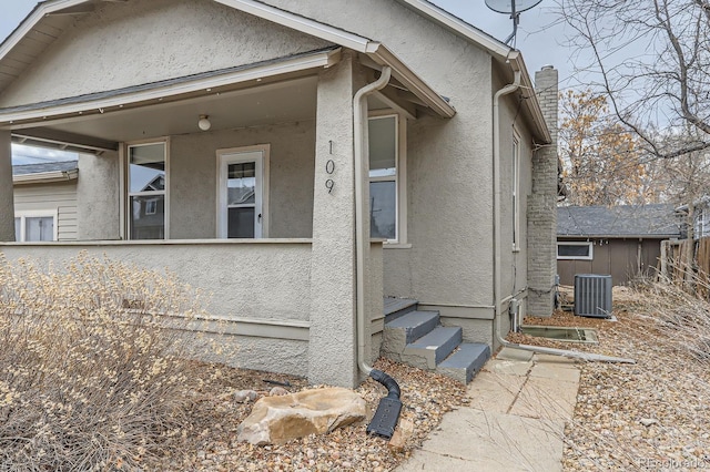 exterior space featuring entry steps, central AC, fence, and stucco siding