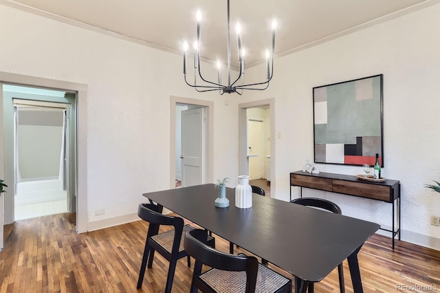 dining space featuring an inviting chandelier, baseboards, ornamental molding, and wood finished floors