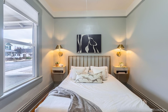 bedroom with baseboards and wood finished floors