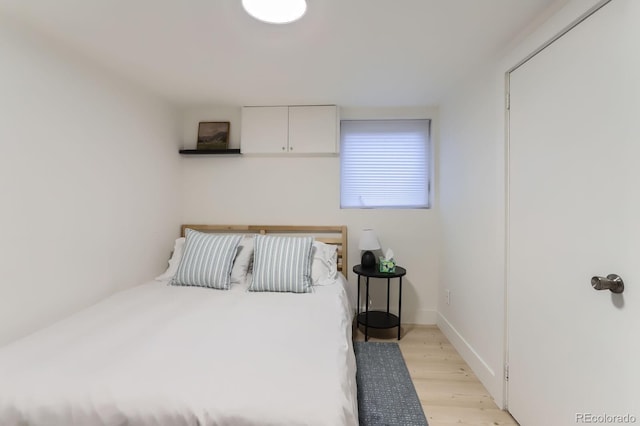 bedroom with light wood-style flooring and baseboards