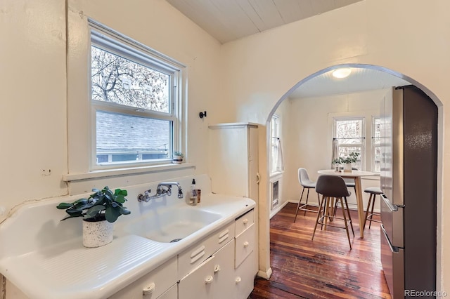 109 W Simpson St, Lafayette, CO 80026 - kitchen featuring freestanding refrigerator, a sink, arched walkways, dark wood finished floors, and light countertops