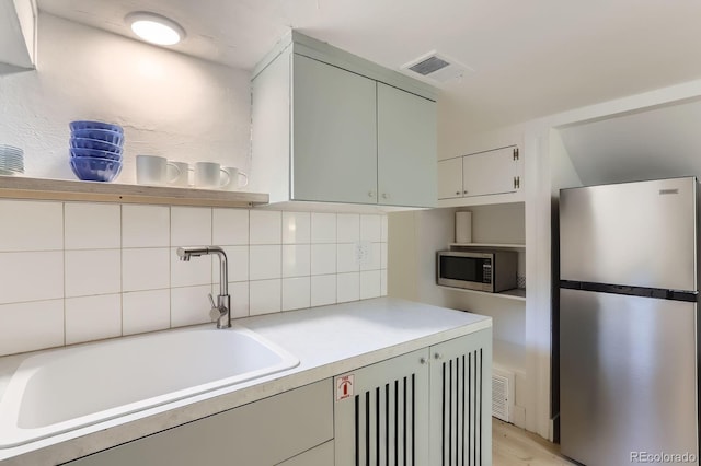 109 W Simpson St, Lafayette, CO 80026 - kitchen featuring stainless steel appliances, a sink, tasteful backsplash, light countertops, and light wood-style floors