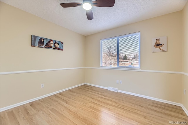 unfurnished room with a textured ceiling, light hardwood / wood-style floors, and ceiling fan