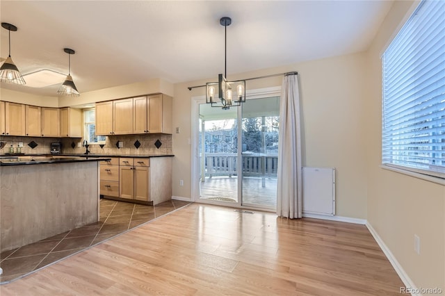 kitchen featuring pendant lighting, a healthy amount of sunlight, and backsplash