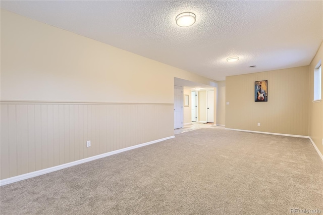 unfurnished room featuring light colored carpet and a textured ceiling