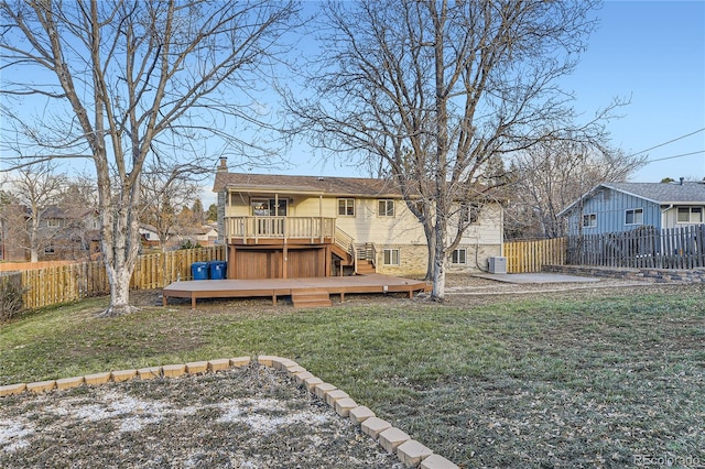 rear view of property with a deck, central AC unit, and a lawn