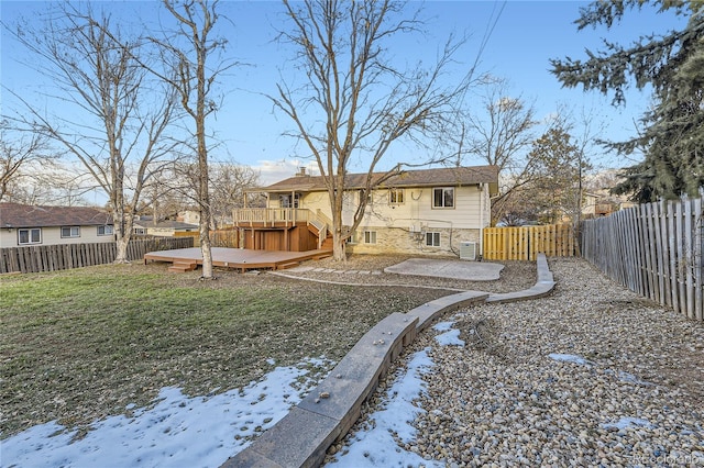 snow covered back of property with a lawn, a wooden deck, and central AC