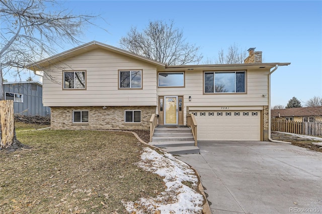 split foyer home with a front lawn and a garage