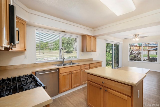 kitchen with dishwasher, a center island, sink, ceiling fan, and light hardwood / wood-style floors