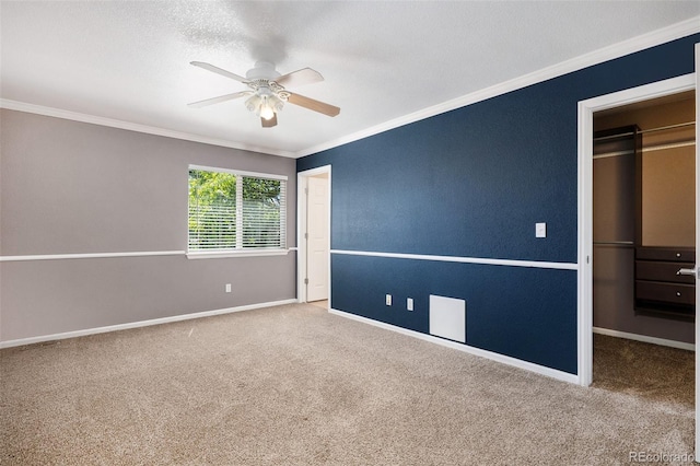 unfurnished bedroom with carpet flooring, ceiling fan, a closet, and ornamental molding