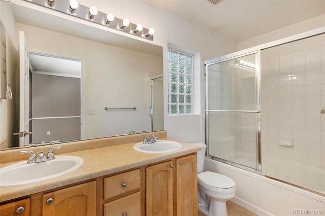 full bathroom featuring vanity, toilet, and enclosed tub / shower combo