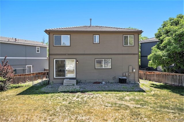 rear view of property featuring a yard and central AC unit