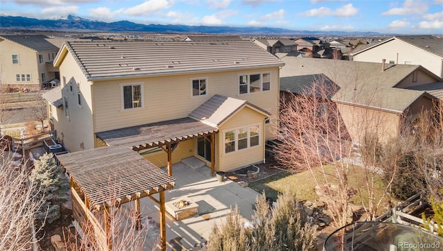 back of property with a pergola and a mountain view