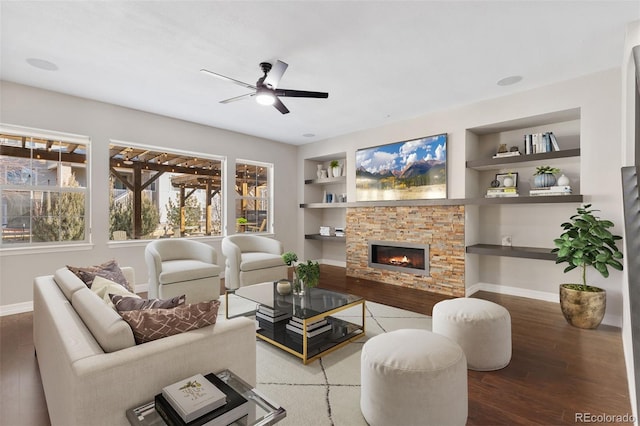 living room with built in shelves, ceiling fan, a fireplace, and hardwood / wood-style floors