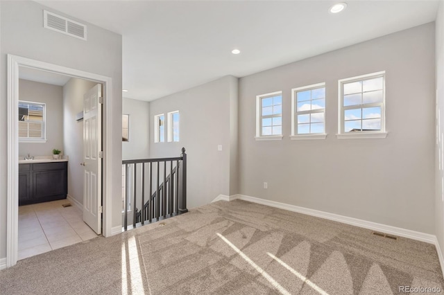 carpeted empty room with sink and plenty of natural light