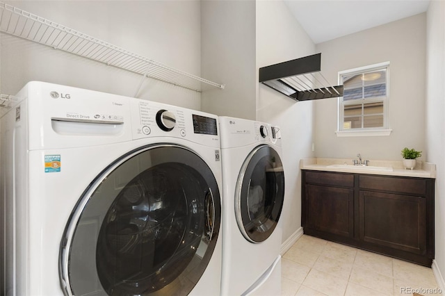 washroom with sink, cabinets, independent washer and dryer, and light tile patterned floors