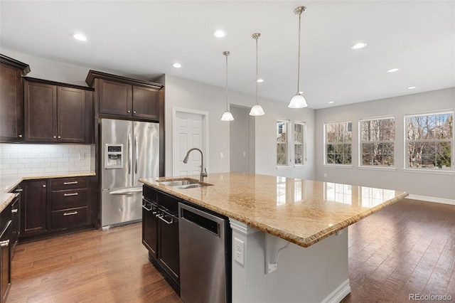 kitchen with tasteful backsplash, a kitchen bar, a kitchen island with sink, appliances with stainless steel finishes, and sink